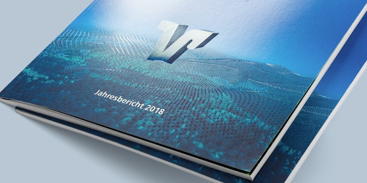 Ein aufgeschlagener gedruckter Geschäftsbericht der Volksbank mit Zahlen, Fotos und einer Doppelseite zur Geschichte des Hauses
